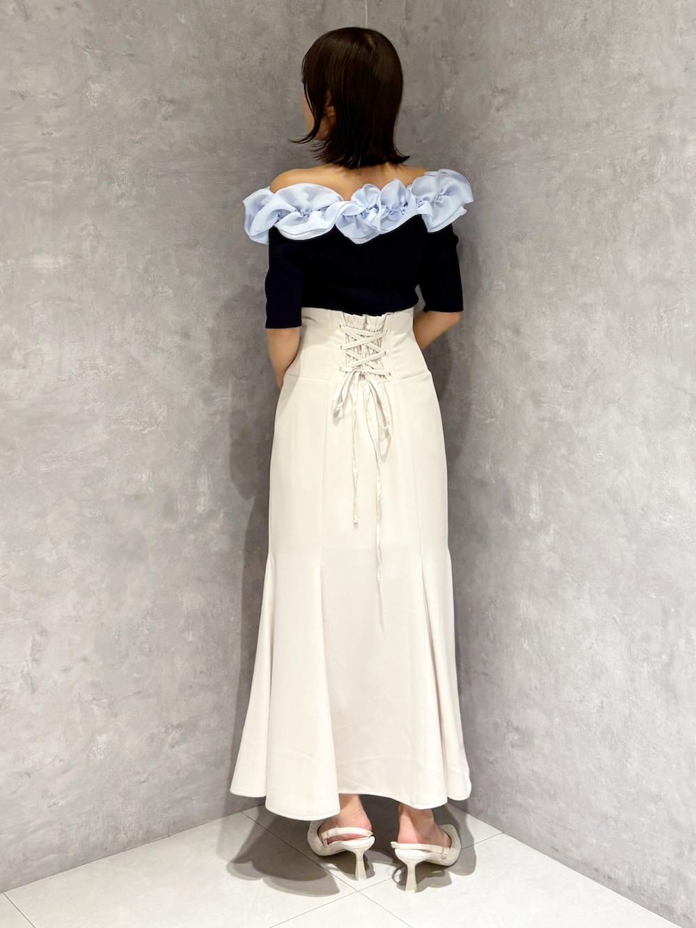 ホワイト系のスカート、ホワイト系のパンプス、ブルー系のニット/セーターを着用したレディースの春コーディネートの4枚目の写真