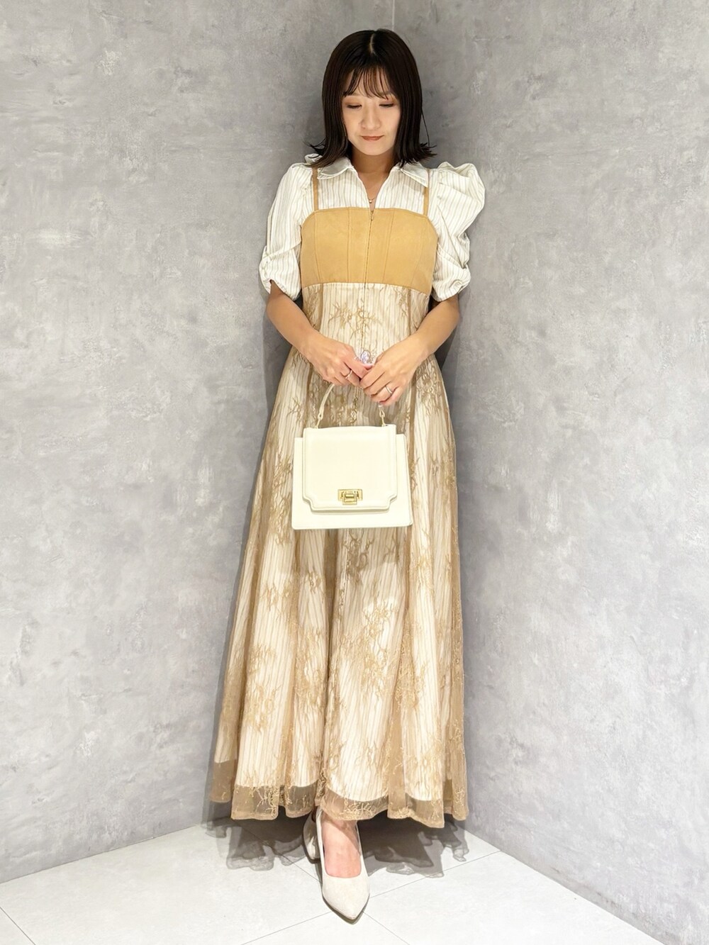 ベージュ系のワンピース、シルバー系のパンプス、ホワイト系のハンドバッグを着用したレディースの夏コーディネートの7枚目の写真