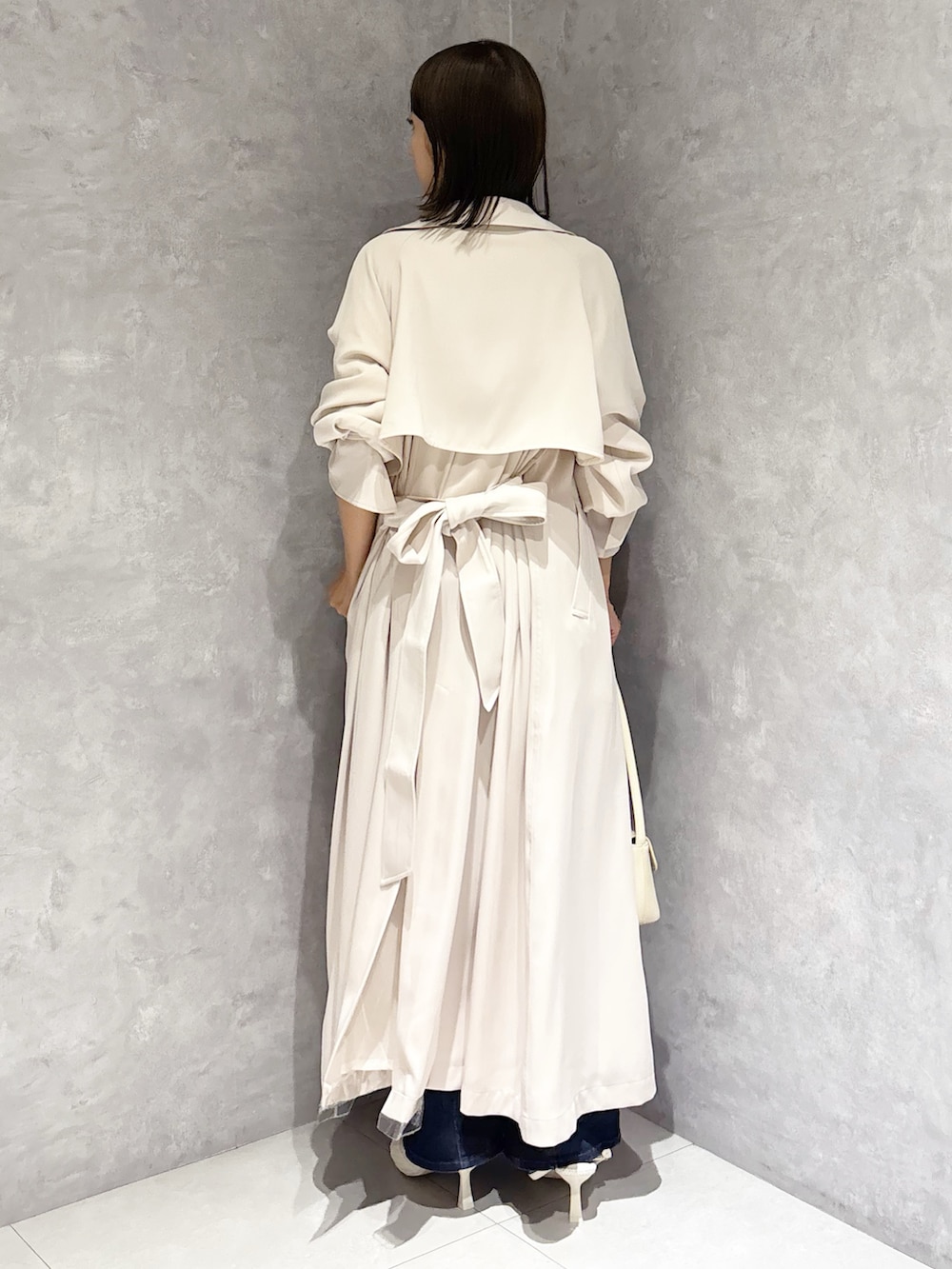 ホワイト系のシャツ/ブラウス、ブルー系のデニムパンツ、ホワイト系のトレンチコートを着用したレディースの春コーディネートの3枚目の写真