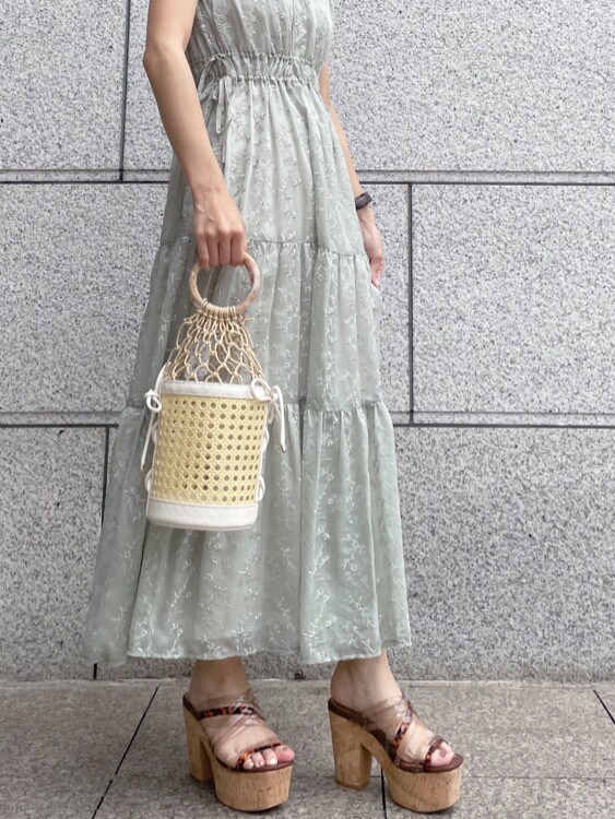 ベージュ系のサンダル、ホワイト系のハンドバッグ、グリーン系のワンピースを着用したレディースの春コーディネートの3枚目の写真