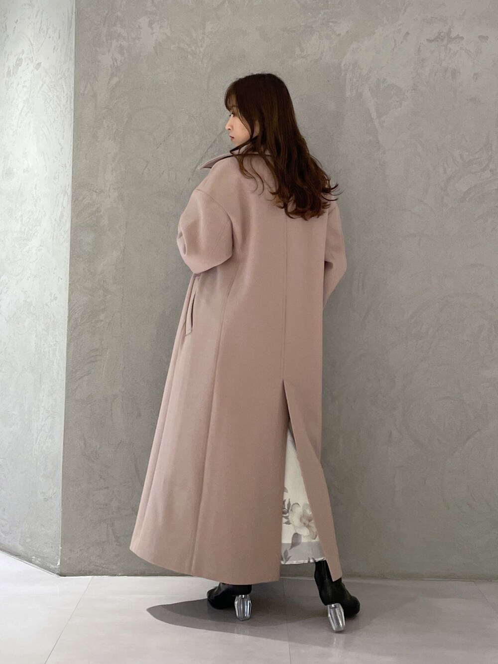 ホワイト系のワンピース、ベージュ系のステンカラーコート、ブラック系のブーツを着用したレディースの冬コーディネートの5枚目の写真