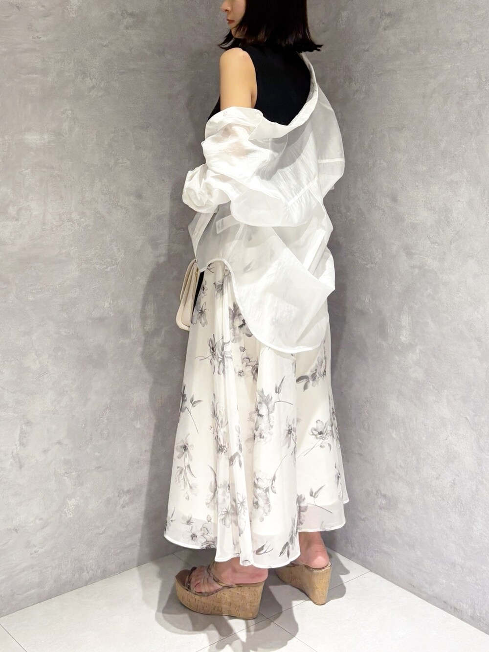 ホワイト系のワンピース、ブラウン系のサンダル、ホワイト系のハンドバッグを着用したレディースの夏コーディネートの3枚目の写真