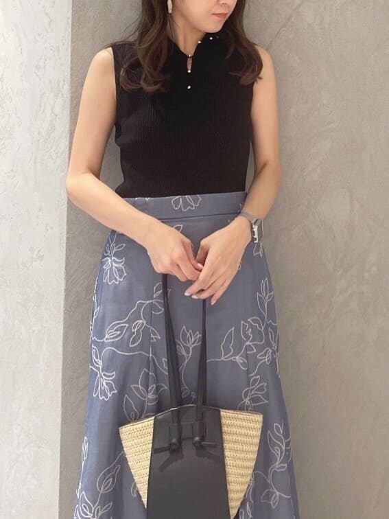 グリーン系のサンダル、ブラック系のニット/セーター、ブルー系のスカートを着用したレディースの夏コーディネートの2枚目の写真