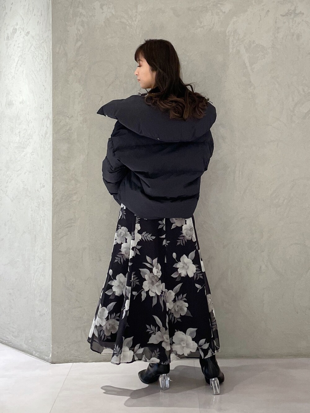 ブラック系のワンピース、ブラック系のダウンジャケット/コート、ブラック系のブーツを着用したレディースの冬コーディネートの4枚目の写真