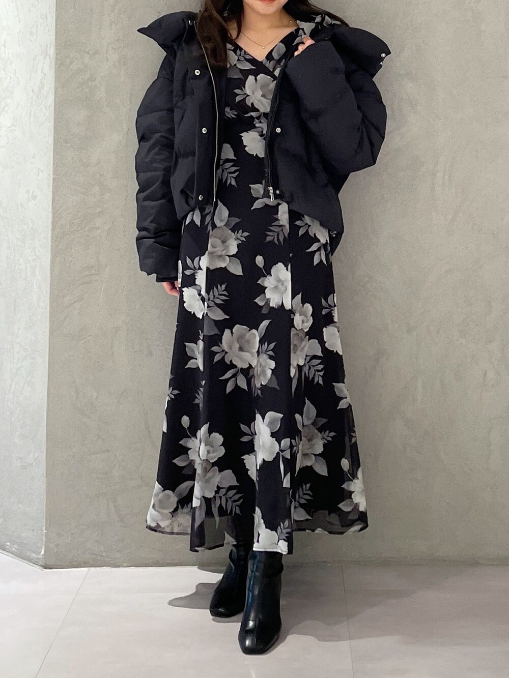 ブラック系のワンピース、ブラック系のダウンジャケット/コート、ブラック系のブーツを着用したレディースの冬コーディネートの7枚目の写真