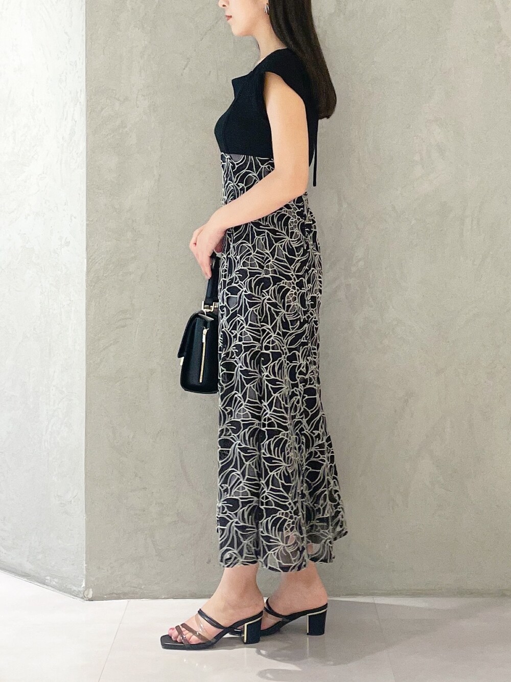 ブラック系のサンダル、ブラック系のショルダーバッグ、ブラック系のワンピースを着用したレディースの夏コーディネートの2枚目の写真