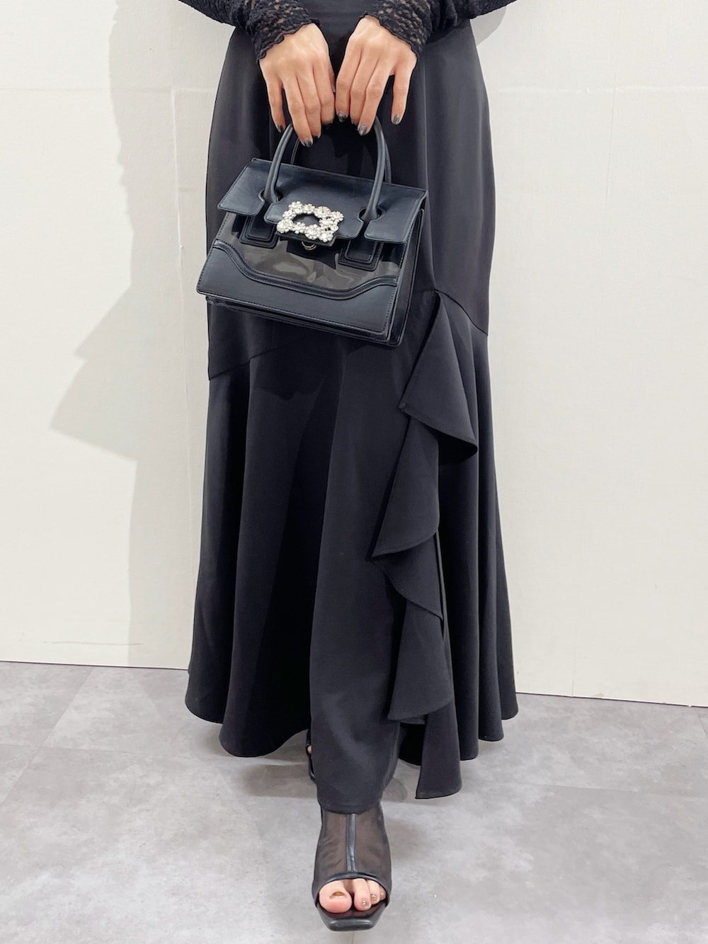 ブラック系のスカート、ブラック系のブーツ、ブラック系のTシャツ/カットソーを着用したレディースの冬コーディネートの4枚目の写真