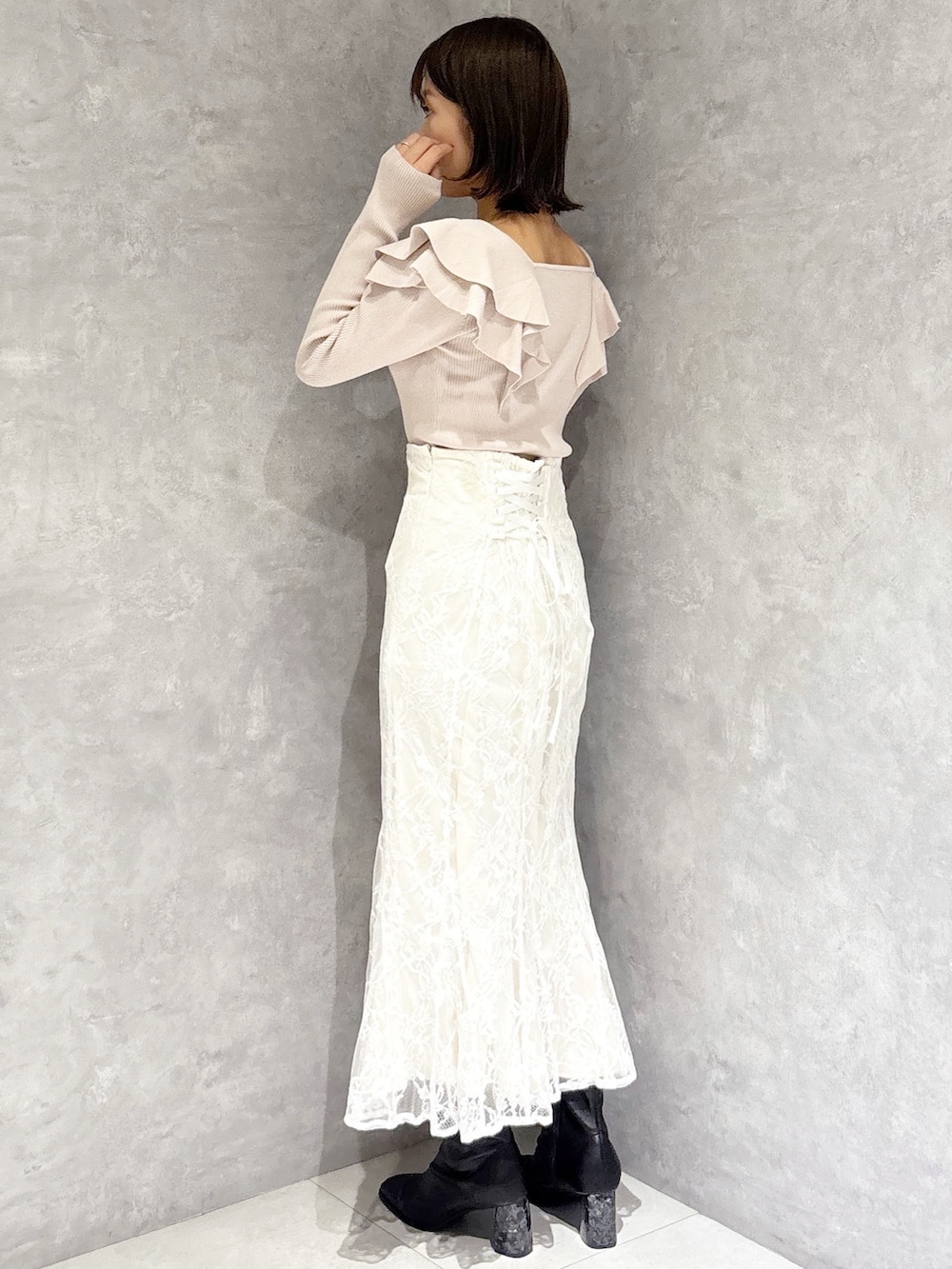 ホワイト系のスカート、ベージュ系のニット/セーター、ブラック系のブーツを着用したレディースの冬コーディネートの3枚目の写真