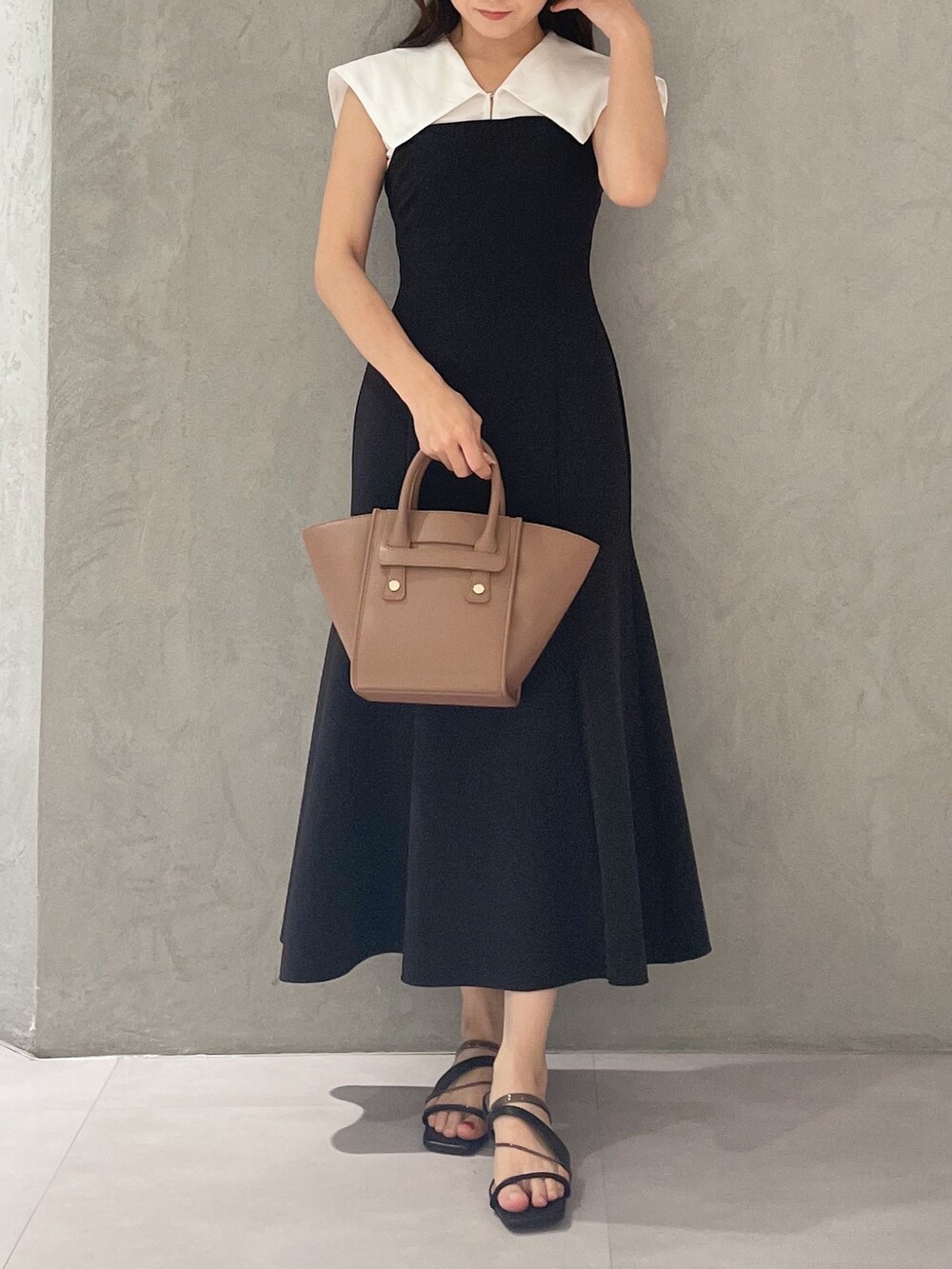 ブラック系のワンピース、ブラック系のサンダル、ブラウン系のトートバッグを着用したレディースの夏コーディネートの6枚目の写真