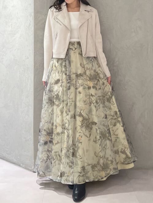 グレー系のライダースジャケット、イエロー系のスカート、ホワイト系のニット/セーターを着用したレディースの秋コーディネートの5枚目の写真