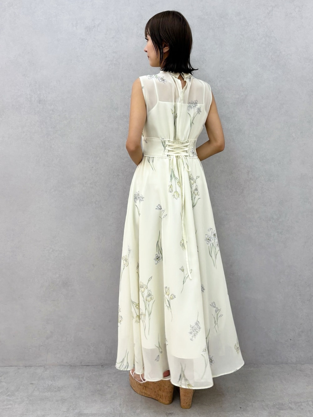 イエロー系のワンピース、その他のサンダルを着用したレディースの春コーディネートの2枚目の写真