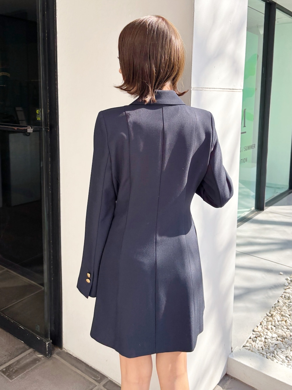 ブルー系のワンピース、ブラック系のブーツを着用したレディースの春コーディネートの5枚目の写真