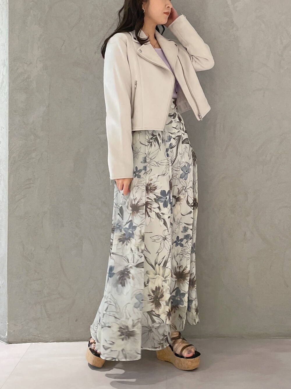 グリーン系のスカート、ピンク系のライダースジャケット、ブラック系のサンダルを着用したレディースの春コーディネートの5枚目の写真