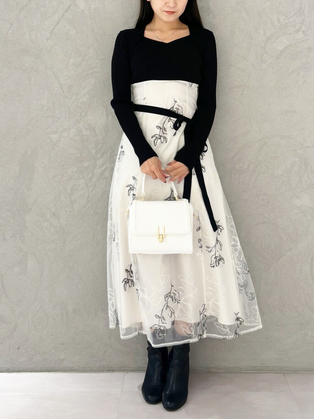 ホワイト系のワンピース、ブラック系のブーツ、ホワイト系のハンドバッグを着用したレディースの秋コーディネートの5枚目の写真