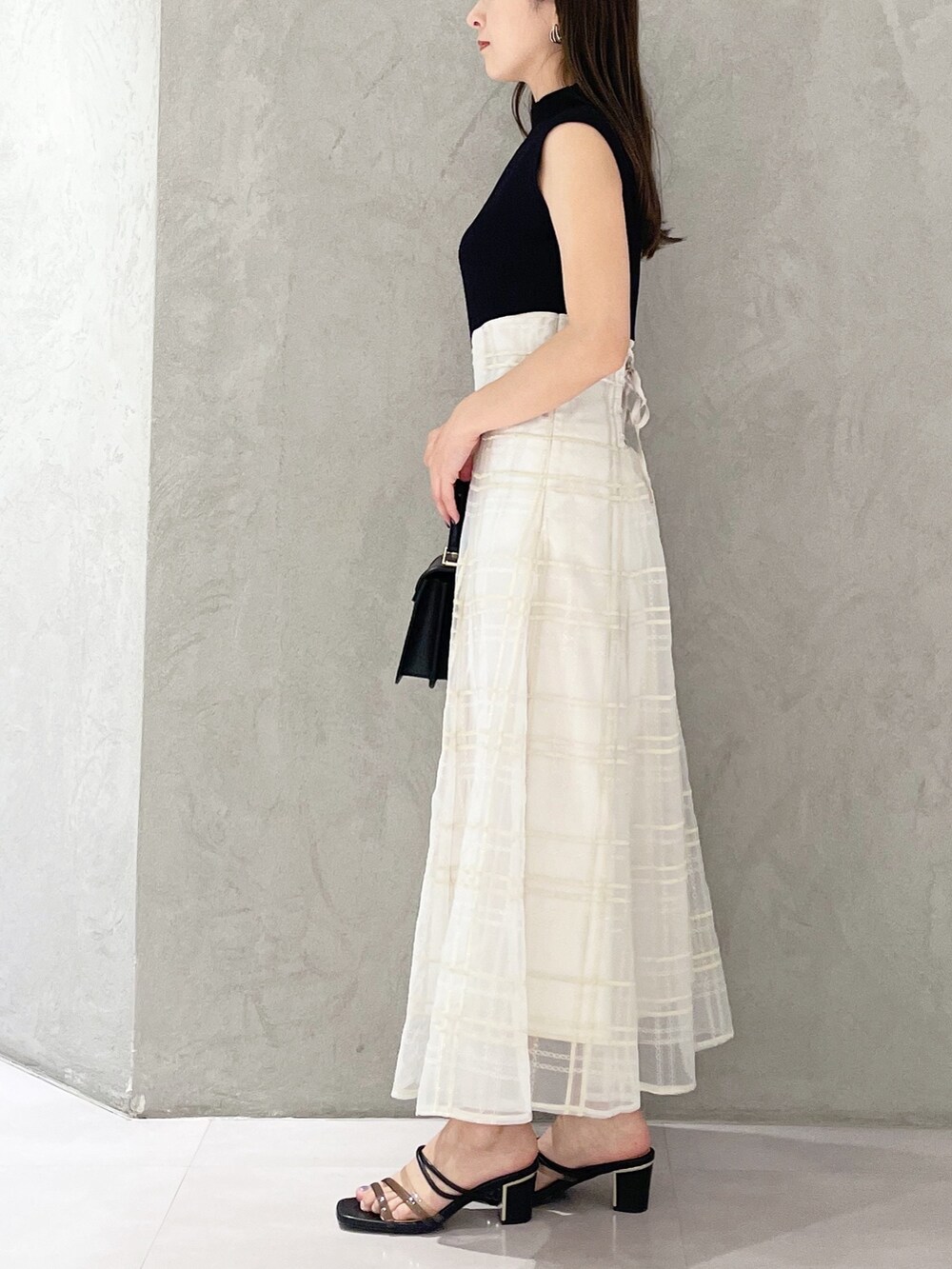 ブラック系のショルダーバッグ、ブラック系のサンダル、ブラック系のワンピースを着用したレディースの春コーディネートの4枚目の写真