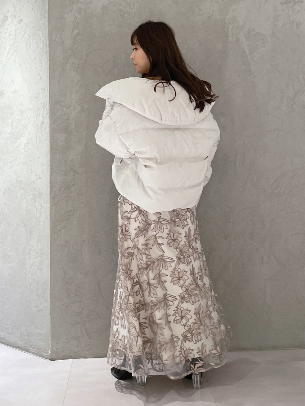 ホワイト系のダウンジャケット/コート、ホワイト系のニット/セーター、ピンク系のスカートを着用したレディースの冬コーディネートの5枚目の写真