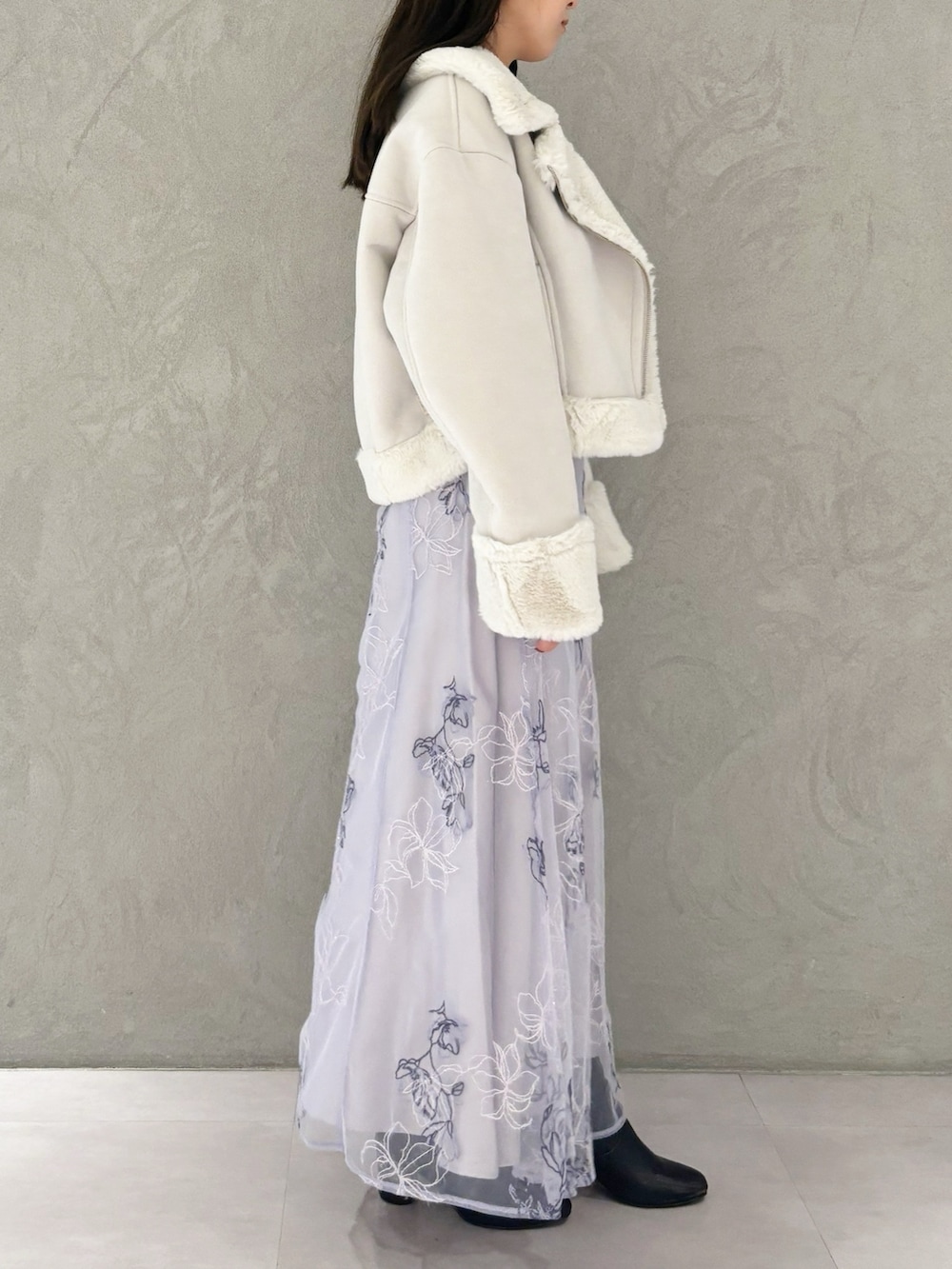 パープル系のワンピース、ブラック系のブーツ、グレー系のムートンコートを着用したレディースの秋コーディネートの5枚目の写真