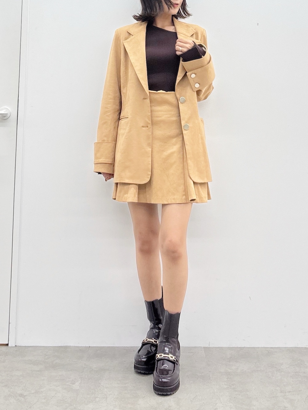 ブラウン系のニット/セーター、ブラウン系のスカート、ブラウン系のテーラードジャケットを着用したレディースの秋コーディネートの8枚目の写真