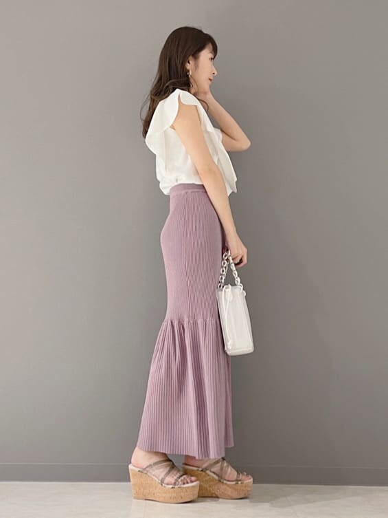 ホワイト系のハンドバッグ、ホワイト系のニット/セーター、グリーン系のサンダルを着用したレディースの春コーディネートの4枚目の写真