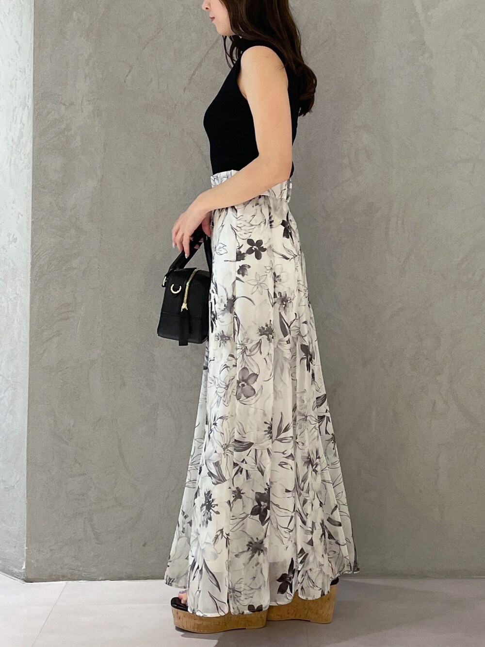 ホワイト系のボストンバッグ、ホワイト系のスカート、ブラック系のニット/セーターを着用したレディースの春コーディネートの6枚目の写真