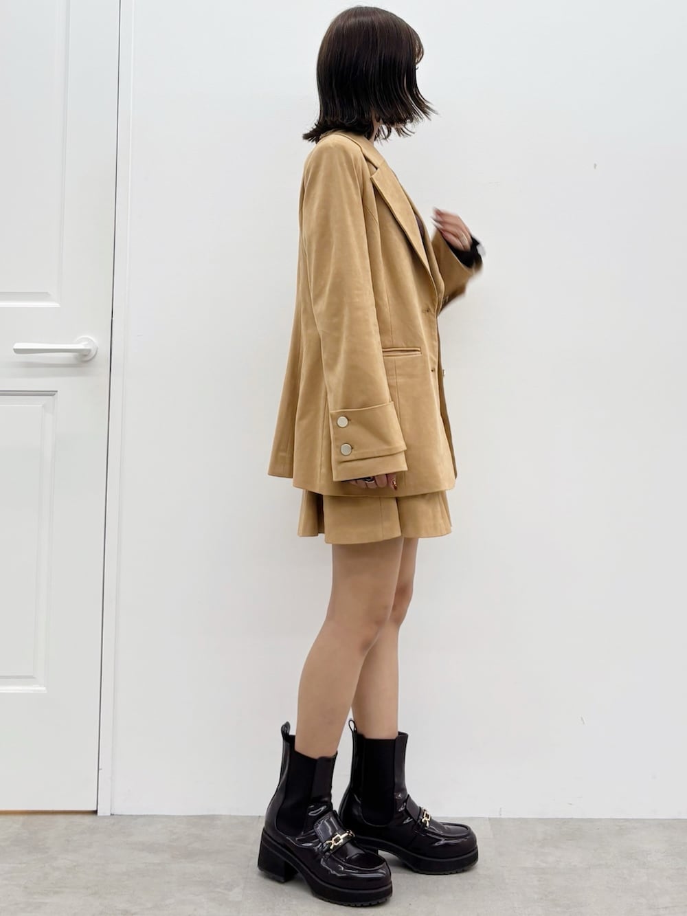 ブラウン系のニット/セーター、ブラウン系のスカート、ブラウン系のテーラードジャケットを着用したレディースの秋コーディネートの7枚目の写真