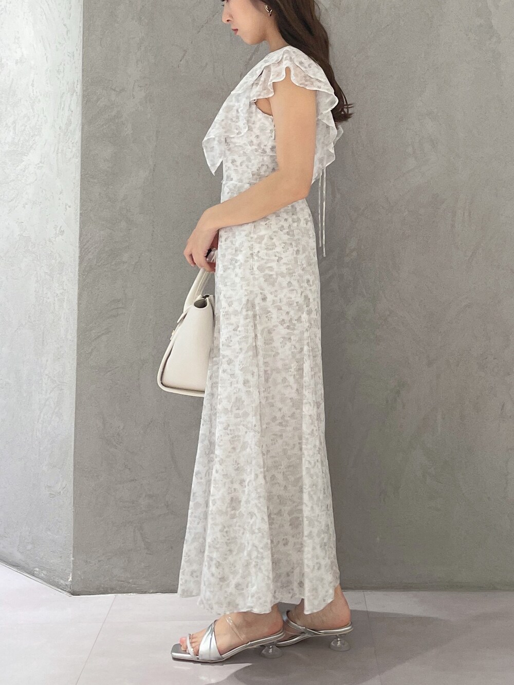 ホワイト系のワンピース、シルバー系のサンダル、ホワイト系のトートバッグを着用したレディースの夏コーディネートの4枚目の写真
