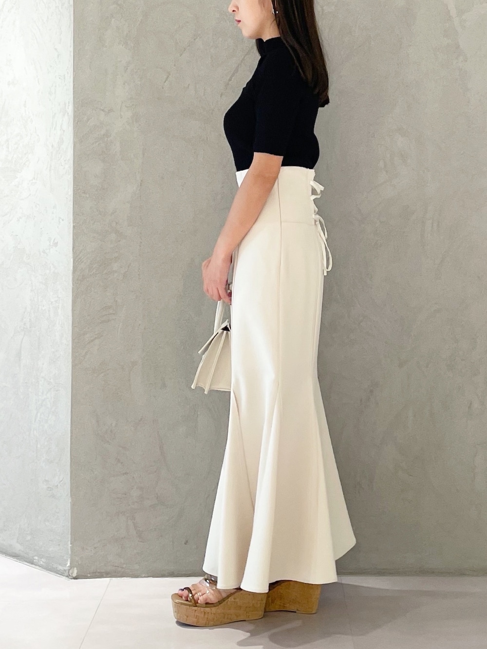 ピンク系のスカート、ブラウン系のサンダル、ベージュ系のショルダーバッグを着用したレディースの夏コーディネートの3枚目の写真