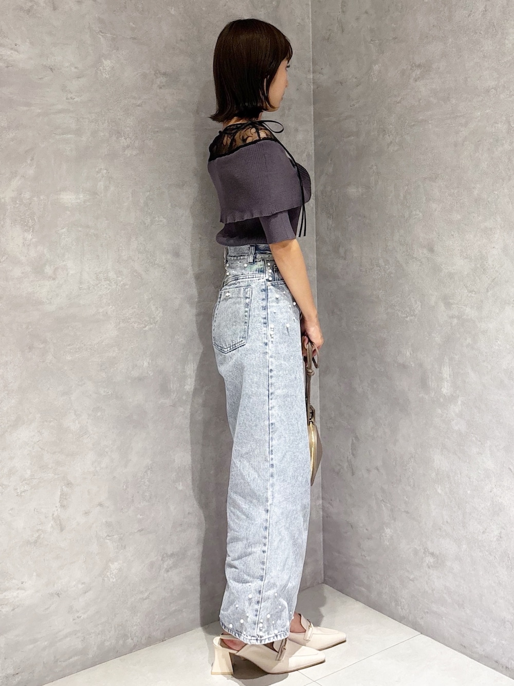 ブルー系のデニムパンツ、ホワイト系のパンプス、グレー系のニット/セーターを着用したレディースの春コーディネートの5枚目の写真