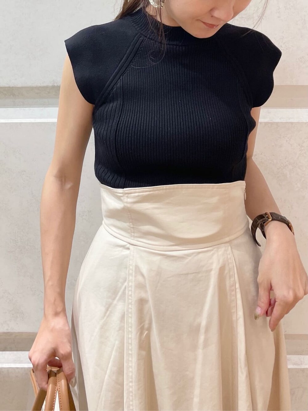 ホワイト系のスカート、ブラック系のニット/セーターを着用したレディースの夏コーディネートの2枚目の写真