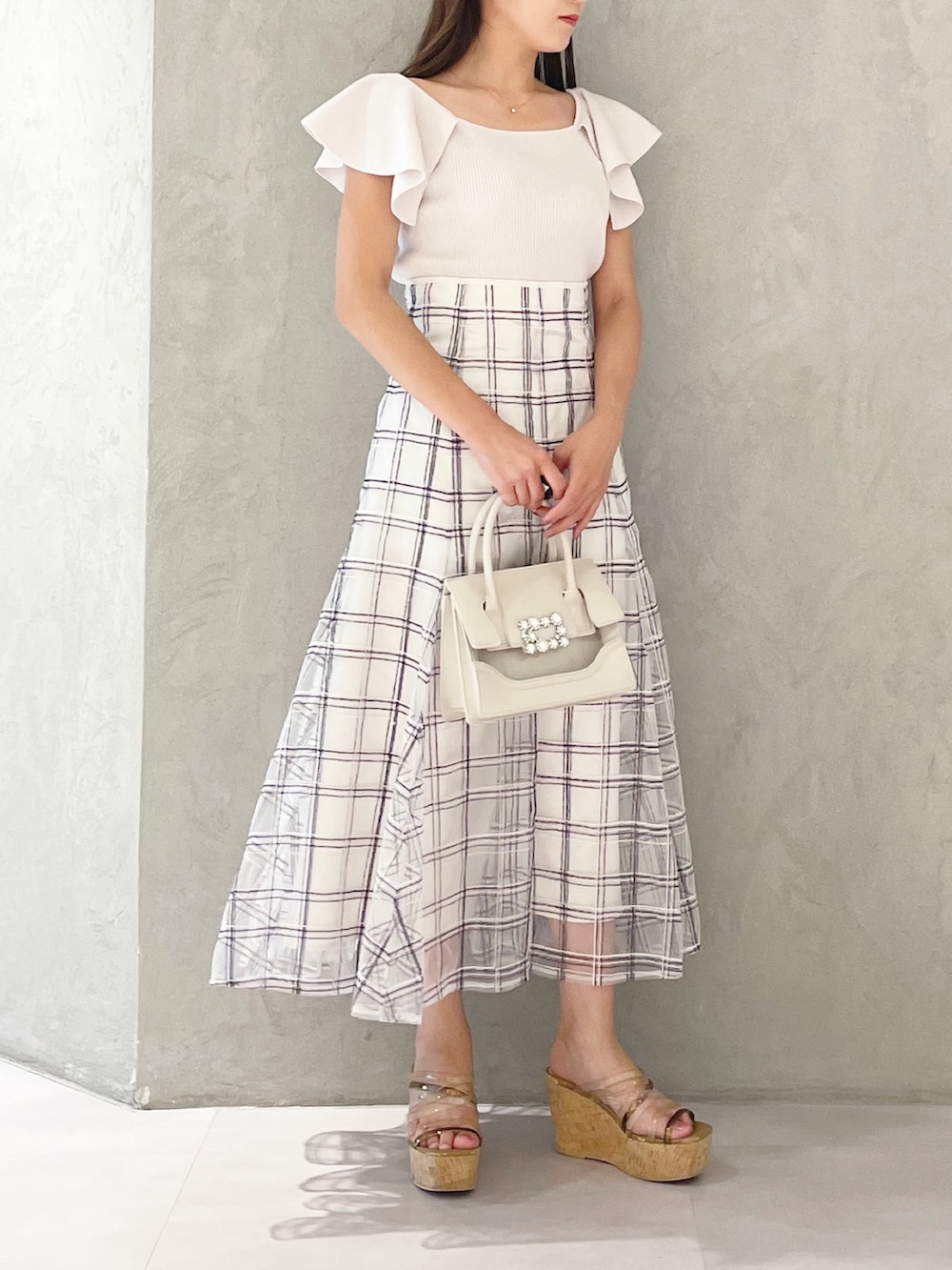 ホワイト系のスカート、ブラウン系のサンダル、ベージュ系のショルダーバッグを着用したレディースの夏コーディネートの2枚目の写真