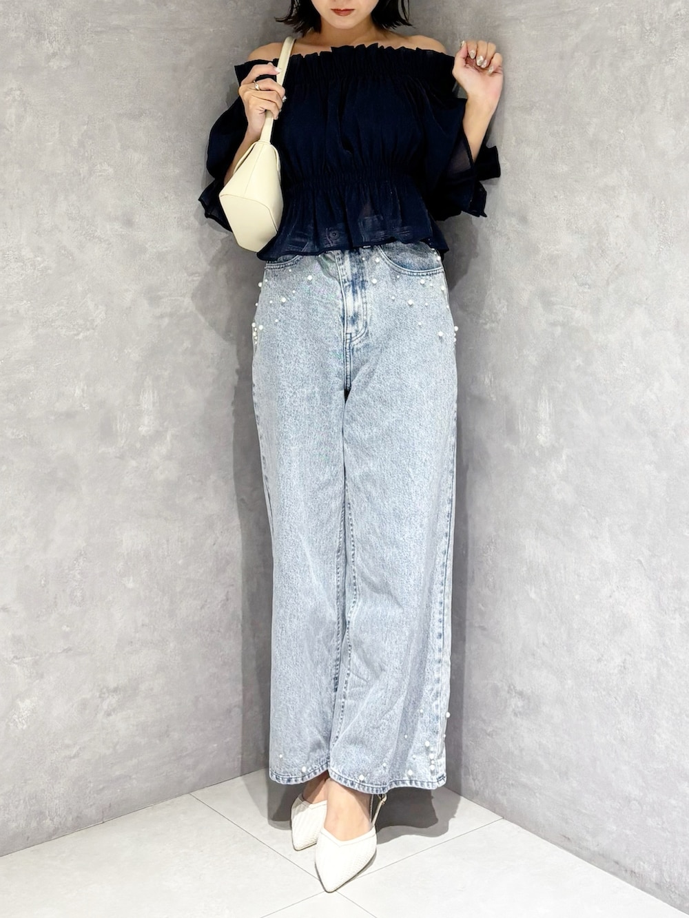 ブルー系のデニムパンツ、ブルー系のシャツ/ブラウス、ホワイト系のハンドバッグを着用したレディースの春コーディネートの5枚目の写真