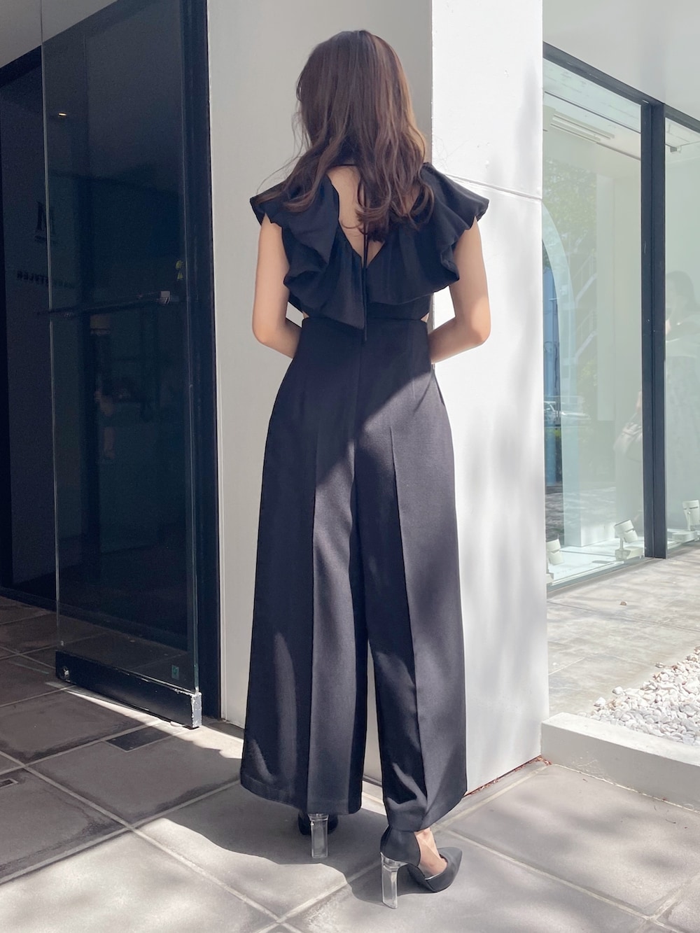 ブラック系のハンドバッグ、ブラック系のパンプス、ブラック系のつなぎ/オールインワンを着用したレディースの春コーディネートの6枚目の写真