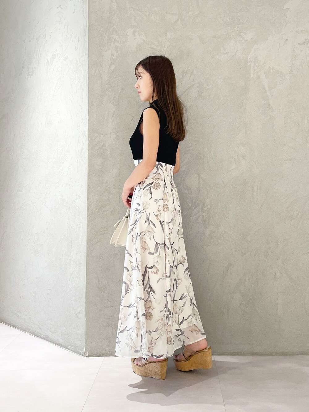 ブラック系のワンピース、ブラウン系のサンダル、ベージュ系のショルダーバッグを着用したレディースの夏コーディネートの7枚目の写真