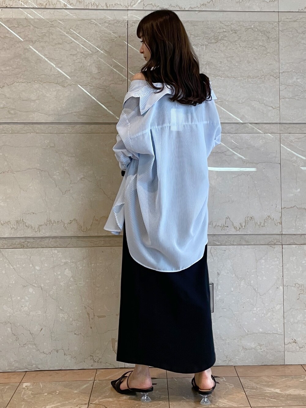 ホワイト系のボストンバッグ、ブラック系のサンダル、ブルー系のシャツ/ブラウスを着用したレディースの春コーディネートの5枚目の写真