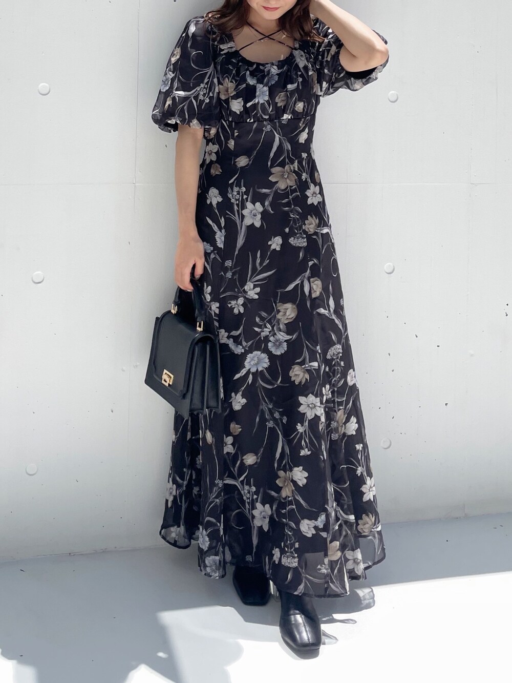 ブラック系のハンドバッグ、ブラック系のワンピースを着用したレディースの夏コーディネートの7枚目の写真