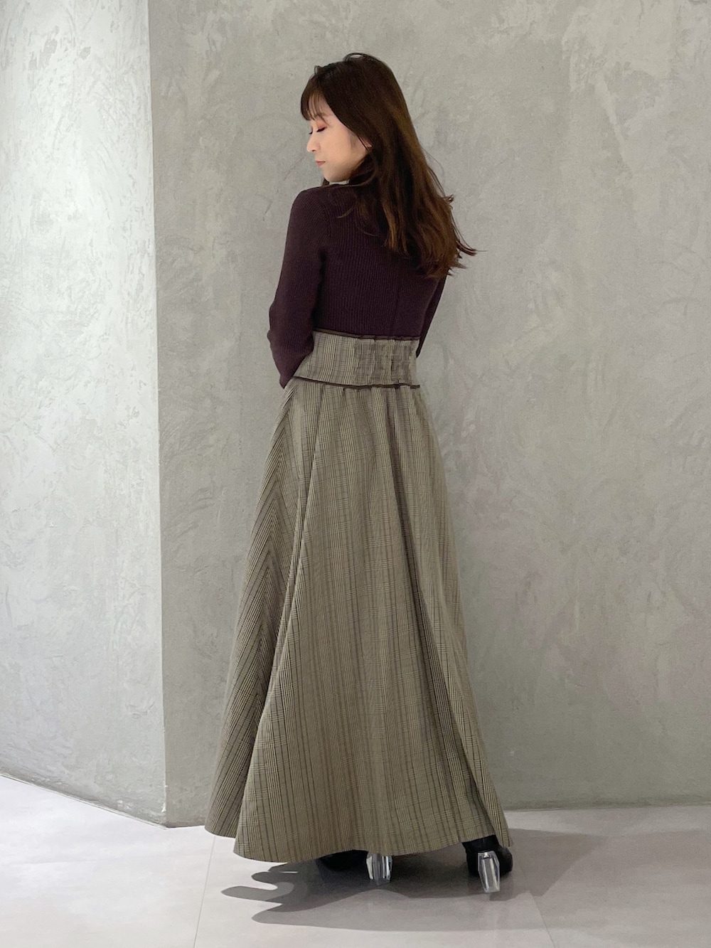 ブラウン系のワンピース、ブラック系のブーツを着用したレディースの冬コーディネートの6枚目の写真