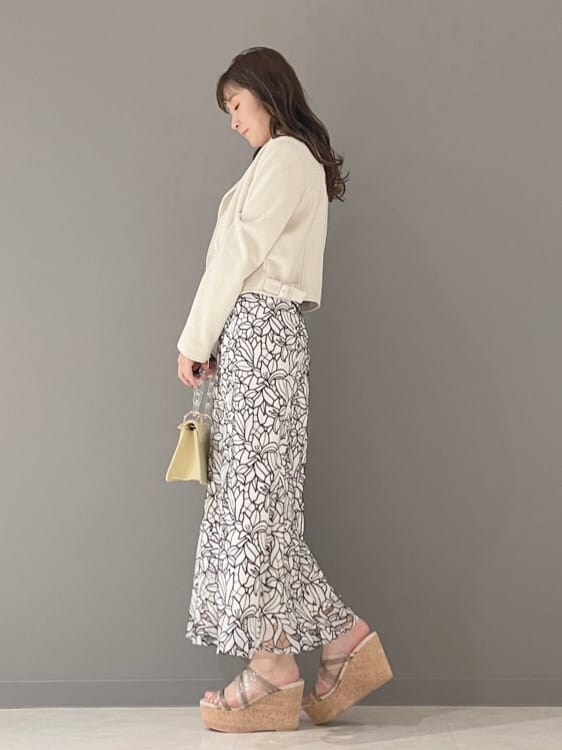 イエロー系のショルダーバッグ、ホワイト系のテーラードジャケット、グリーン系のサンダルを着用したレディースの春コーディネートの6枚目の写真