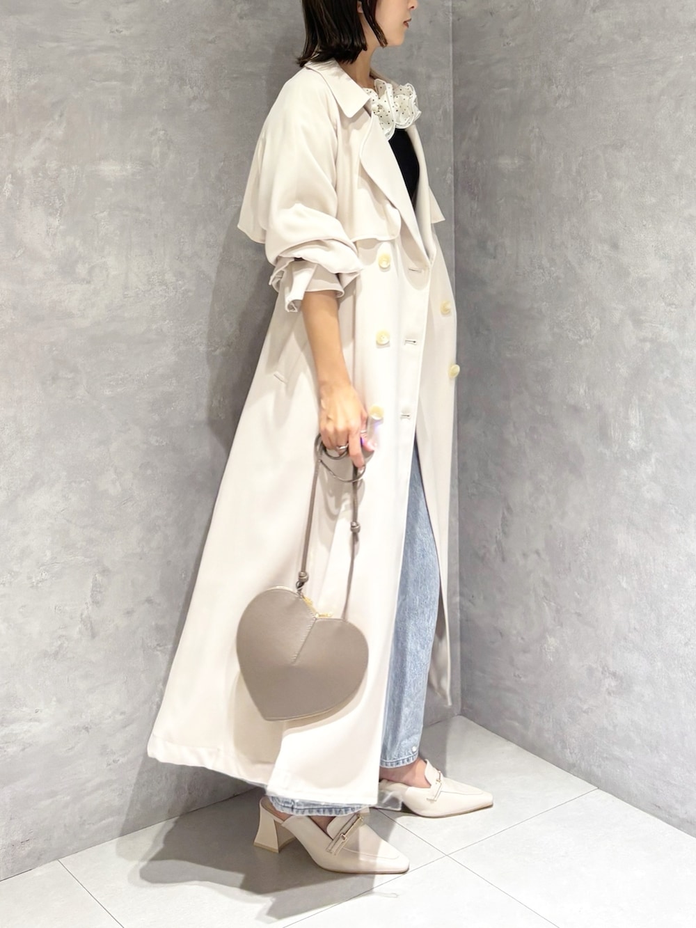 ブルー系のデニムパンツ、その他のニット/セーター、ホワイト系のトレンチコートを着用したレディースの春コーディネートの2枚目の写真