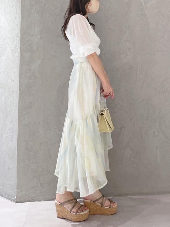 グリーン系のサンダル、グリーン系のスカート、ホワイト系のニット/セーターを着用したレディースの春コーディネートの3枚目の写真