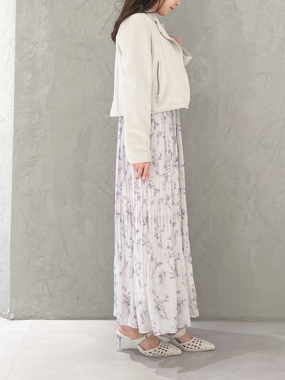 ピンク系のワンピース、ホワイト系のパンプス、ホワイト系のライダースジャケットを着用したレディースの春コーディネートの4枚目の写真