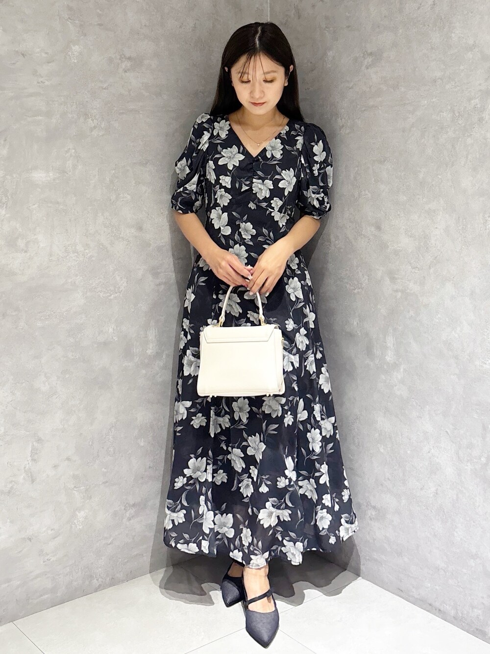 ブルー系のワンピース、ブルー系のパンプス、ホワイト系のハンドバッグを着用したレディースの春コーディネートの5枚目の写真