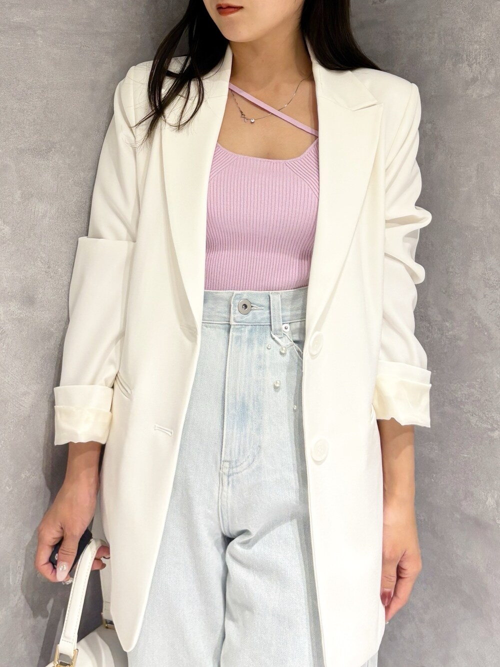 ブルー系のデニムパンツ、ホワイト系のパンプス、ホワイト系のハンドバッグを着用したレディースの冬コーディネートの8枚目の写真