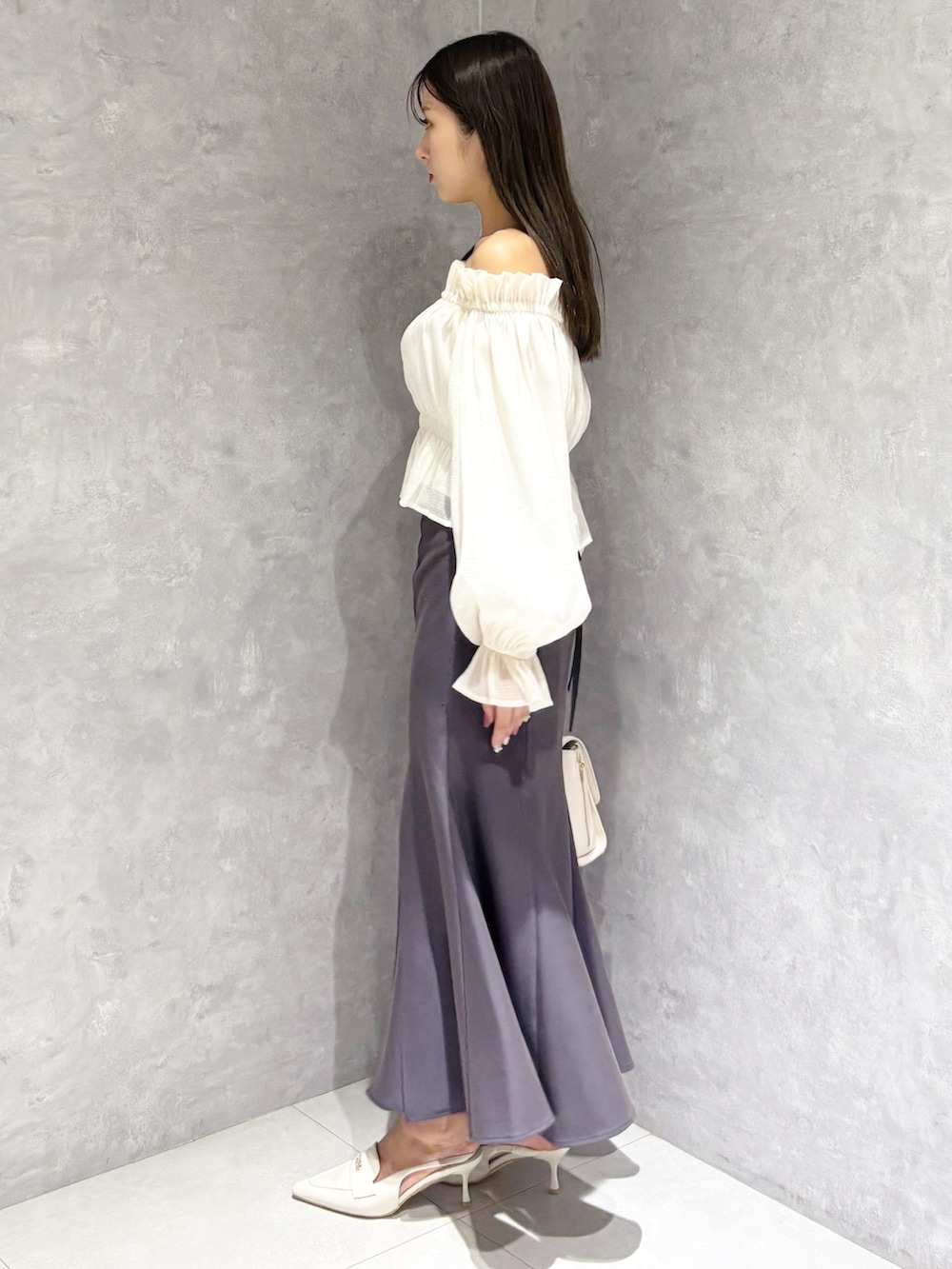 ホワイト系のハンドバッグ、ホワイト系のパンプス、ホワイト系のシャツ/ブラウスを着用したレディースの春コーディネートの2枚目の写真