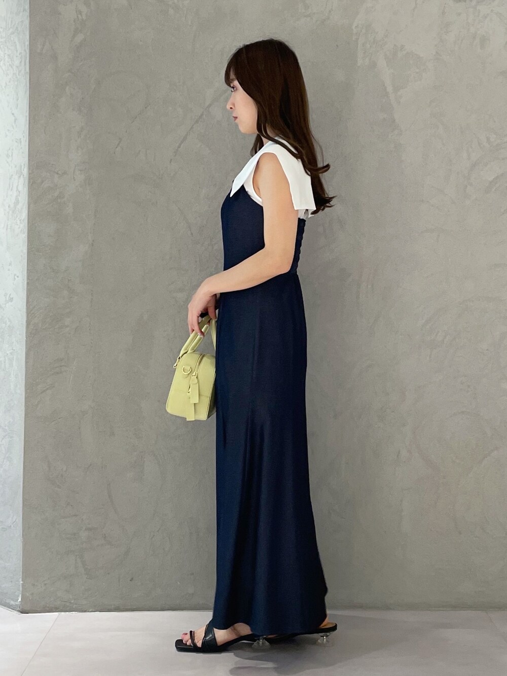 ブルー系のワンピース、イエロー系のボストンバッグ、ブラック系のサンダルを着用したレディースの春コーディネートの3枚目の写真