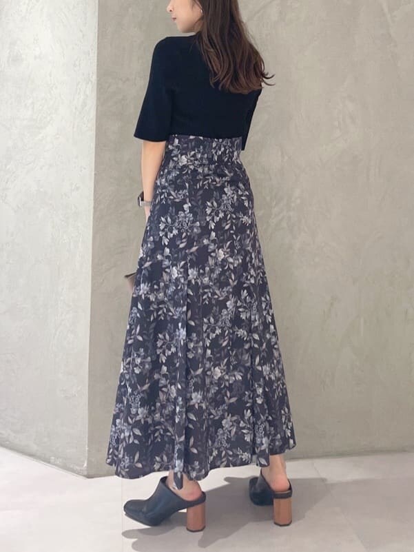 ブラック系のニット/セーター、ブラウン系のハンドバッグ、ブルー系のスカートを着用したレディースの夏コーディネートの5枚目の写真