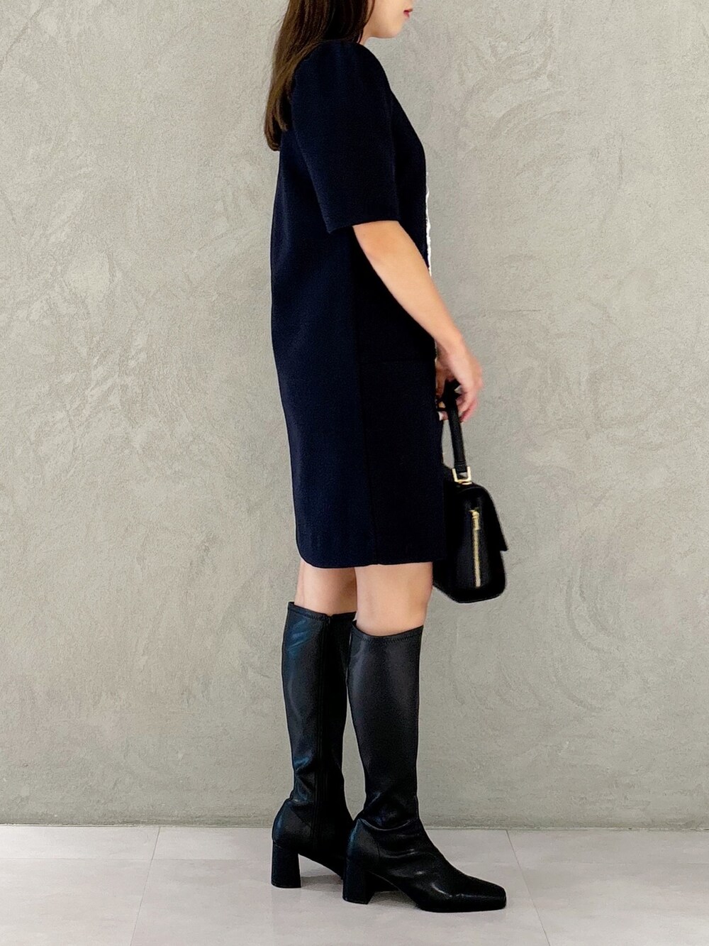 ブルー系のワンピース、ブラック系のブーツ、ブラック系のショルダーバッグを着用したレディースの秋コーディネートの3枚目の写真