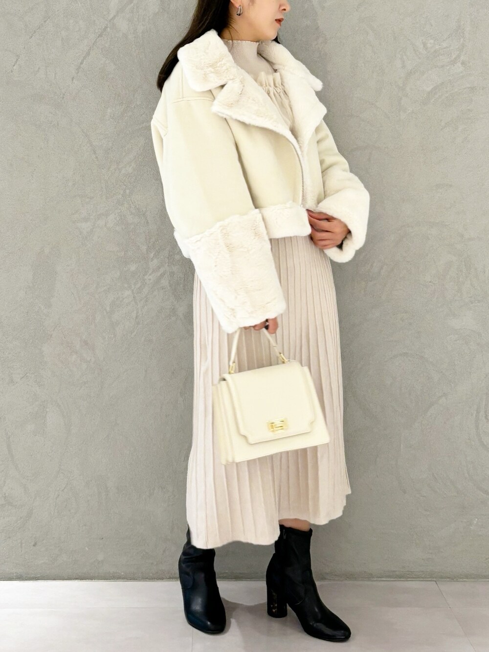 ホワイト系のワンピース、ブラック系のブーツ、ホワイト系のハンドバッグを着用したレディースの秋コーディネートの2枚目の写真