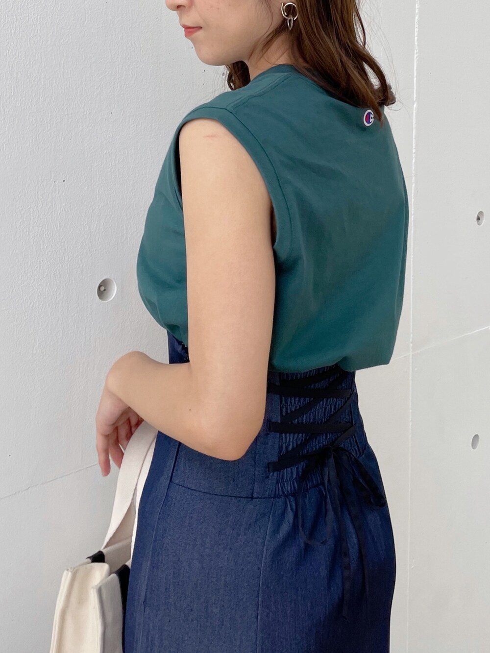 グレー系のハンドバッグ、ブラック系のサンダル、ブルー系のスカートを着用したレディースの春コーディネートの5枚目の写真