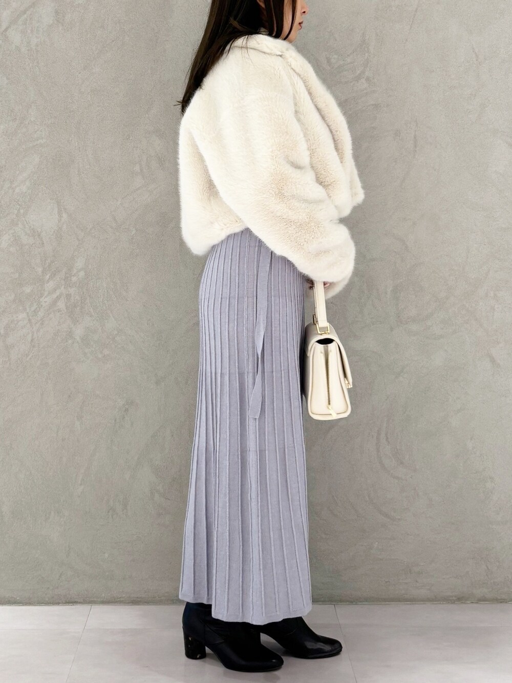 ブルー系のワンピース、ブラック系のブーツ、ホワイト系のその他アウターを着用したレディースの冬コーディネートの5枚目の写真