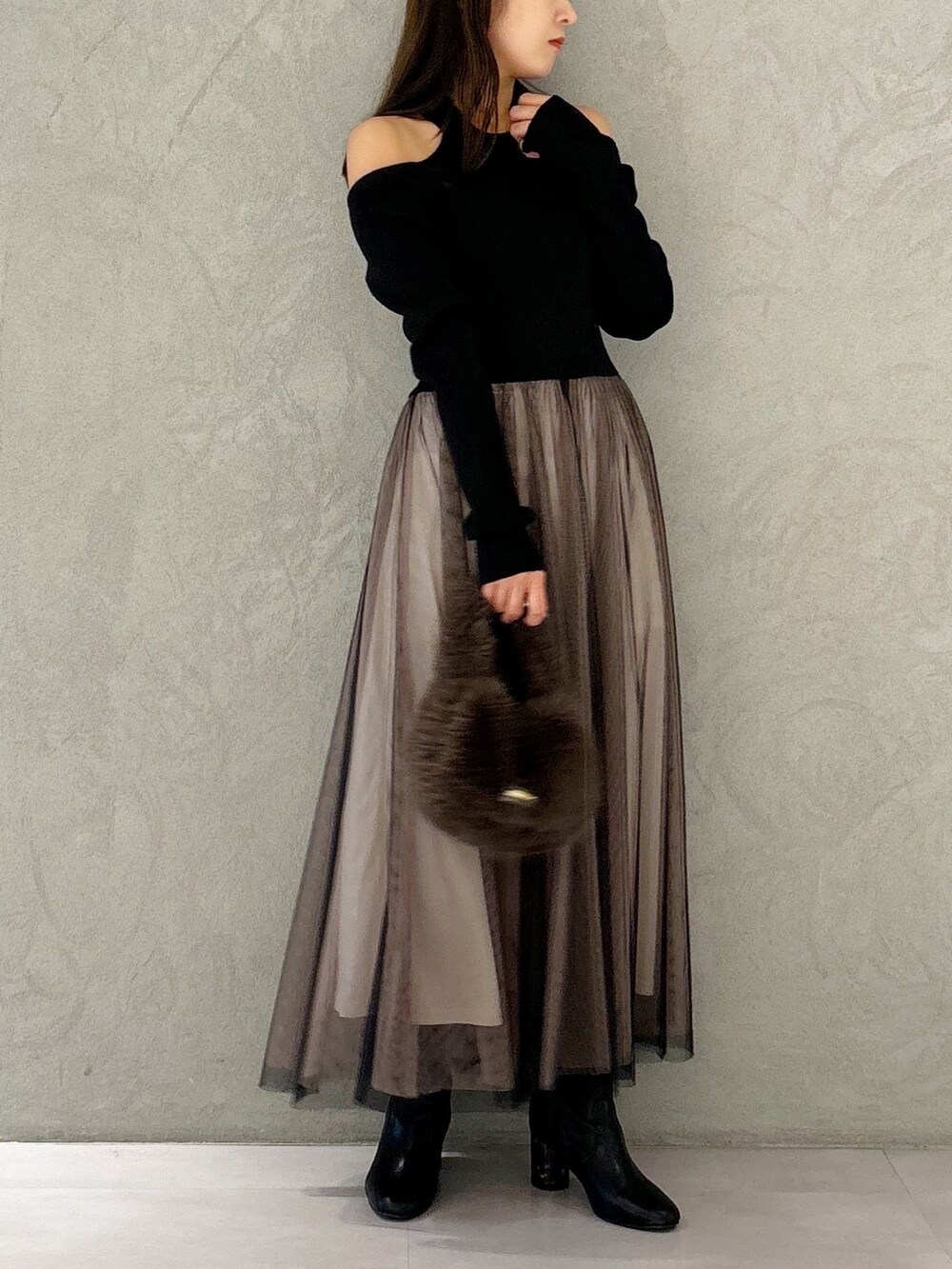 ブラック系のワンピース、ブラック系のブーツ、ブラウン系のハンドバッグを着用したレディースの秋コーディネートの8枚目の写真